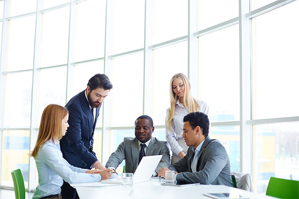 a group of business people sitting around a table.