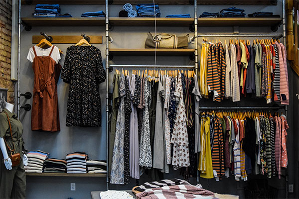 a clothing store with clothes hanging on a rack.