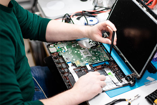 a man is working on a laptop computer.