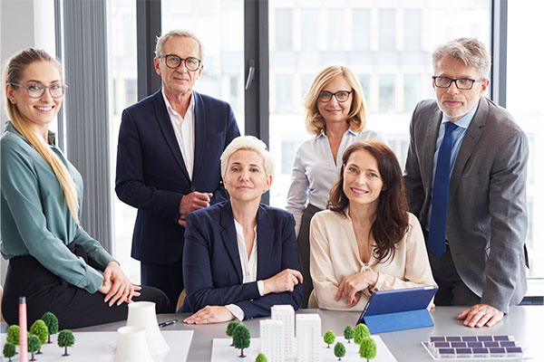 a group of people standing around a table.