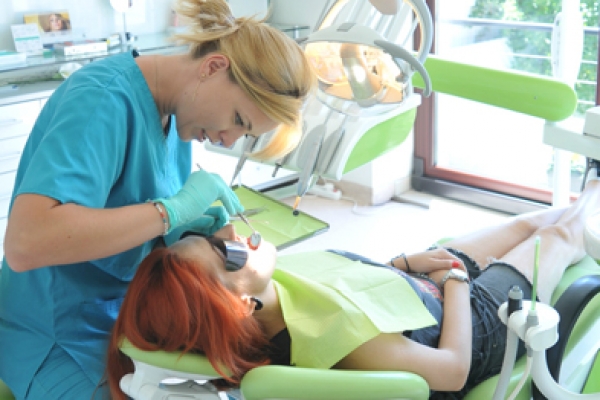 a woman getting her teeth checked by a dentist.
