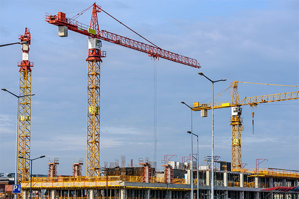 a group of cranes that are next to a building.