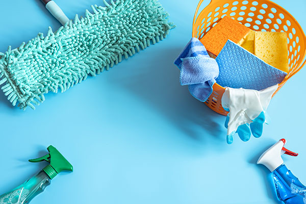 a bucket of cleaning supplies on a blue background.