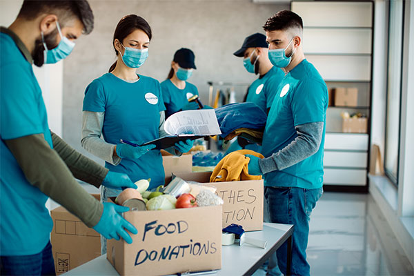 a group of people standing around a box of food.