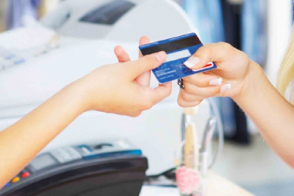 a woman holding a credit card and a cell phone.