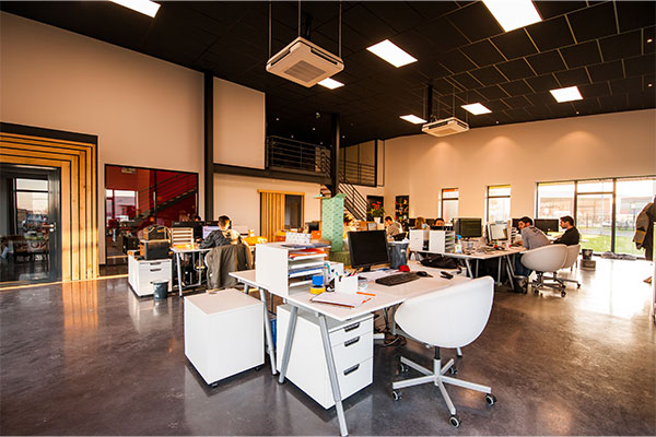 a group of people sitting at desks in a large room.