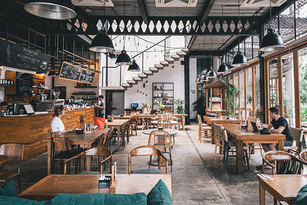 a restaurant filled with lots of tables and chairs.