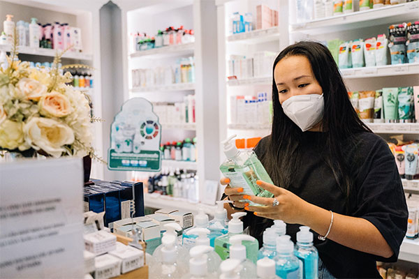 a woman wearing a face mask in a pharmacy.