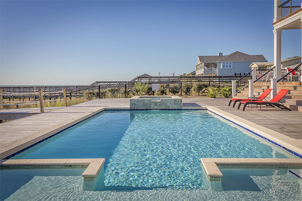 a swimming pool with a deck and chairs.