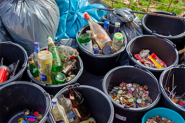 a bunch of buckets filled with bottles and cans.