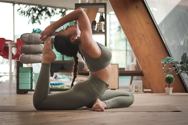 a woman in a yoga pose on the floor.